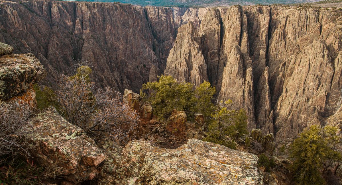 Breathtaking view from the Black Canyon of the Gunnison National Park, featuring rugged cliffs and deep gorges under a cloudy sky. One of the top national parks near Colorado