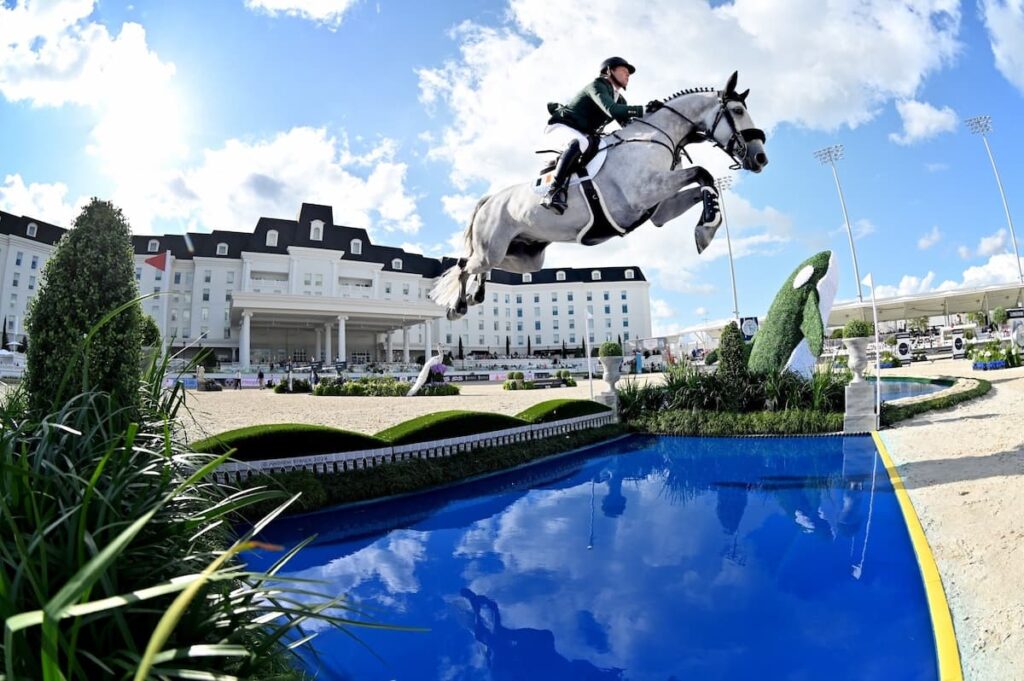 Equestrian horse jumping on a white horse in front of the World Equestrian Center in Ocala Florida