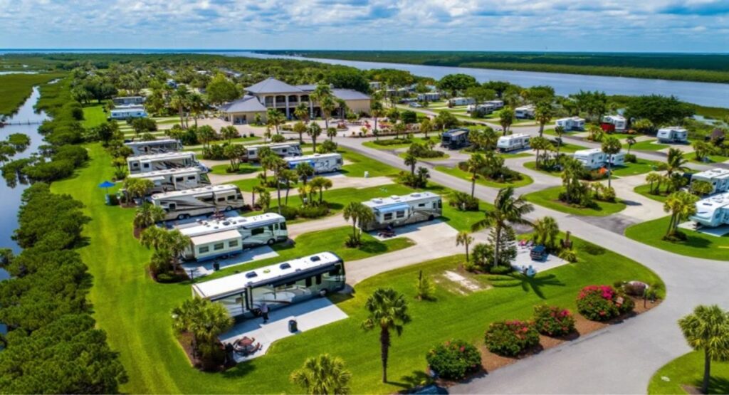Luftaufnahme eines Wohnmobilparks in Florida mit großem Clubhaus, Wohnmobilen auf Rasenstellplätzen und Lage am Wasser