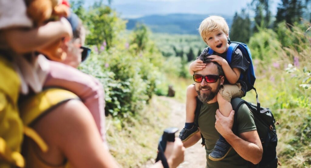 Parents hiking with young children on a forest trail in British Columbia, highlighting family-friendly outdoor activities while RV camping