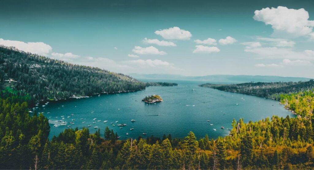 Aerial view of Emerald Bay at Lake Tahoe with Fannette Island at the center, dotted with boats and framed by dense pine forests 
